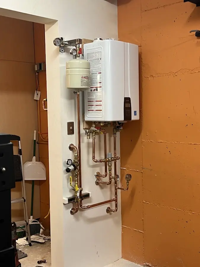 Plumbing technician inspecting water heater connections in Mount Joy